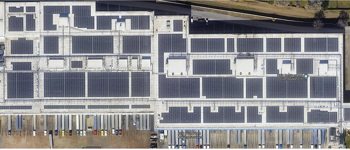 A supermarket refrigerated-products fulfillment center with approximately 100,000 panels on its roof. To get a sense of scale, notice the little “fringes” along the bottom of the building are tractor-trailers. (photo by DigitalMedia R&D)